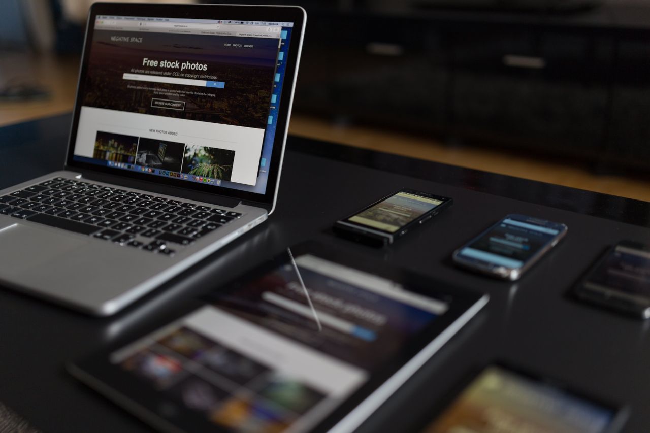 Un espace de travail contemporain mettant en scène un ordinateur portable, une tablette et des smartphones, idéal pour les usages technologiques et freelances.